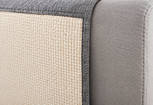 Close-up of SofaGuard natural sisal scratching surface and grey fabric on a sofa armrest
